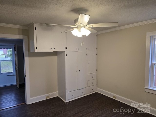 unfurnished bedroom featuring a textured ceiling, ceiling fan, crown molding, and dark hardwood / wood-style floors