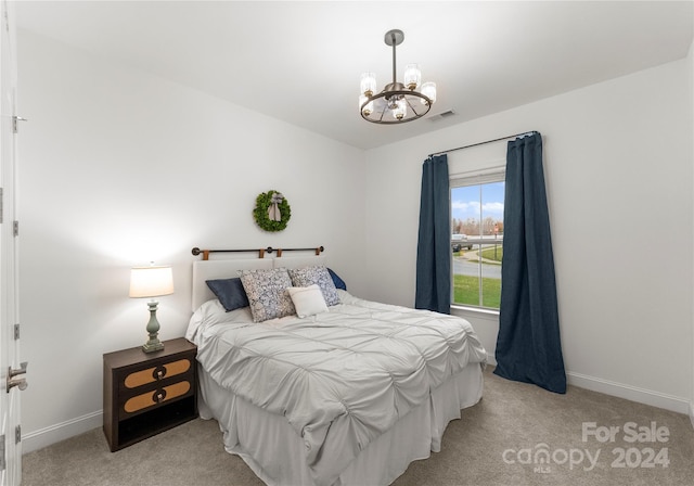 bedroom featuring a notable chandelier and light carpet