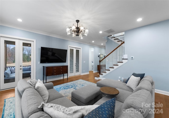 living room featuring french doors, an inviting chandelier, ornamental molding, and hardwood / wood-style floors