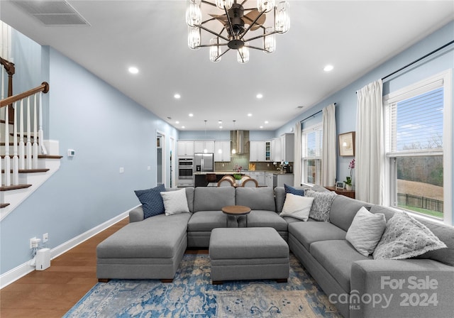 living room with dark wood-type flooring and a chandelier