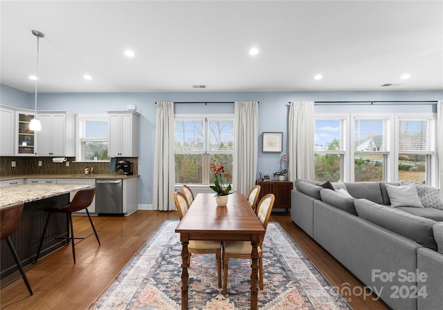 dining area featuring wood-type flooring, plenty of natural light, and sink