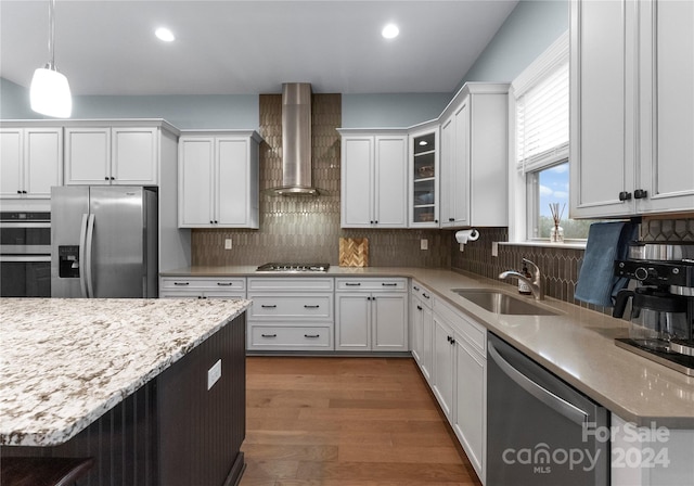 kitchen with sink, stainless steel appliances, wall chimney range hood, dark hardwood / wood-style flooring, and white cabinets