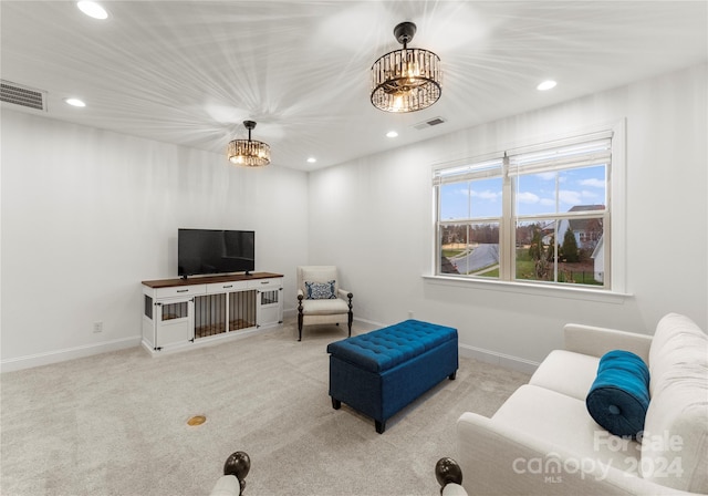 living room featuring light colored carpet and an inviting chandelier