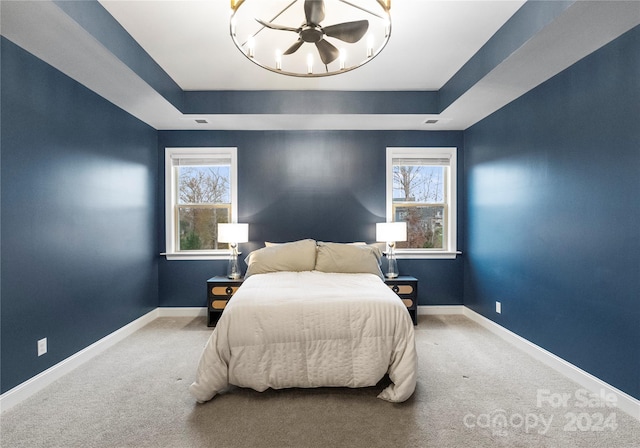 bedroom with carpet flooring and a tray ceiling