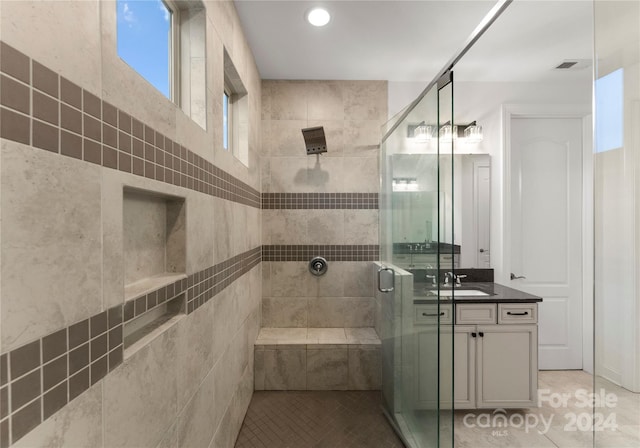 bathroom with tile patterned flooring, vanity, and an enclosed shower