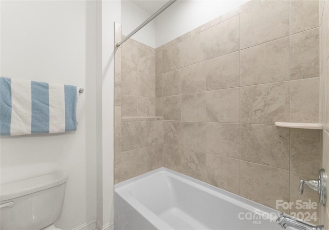 bathroom featuring tiled shower / bath combo and toilet