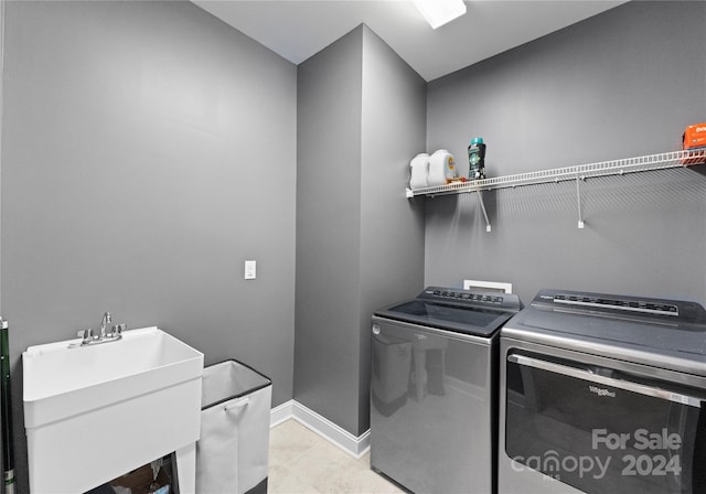 laundry room with separate washer and dryer, sink, and light tile patterned flooring