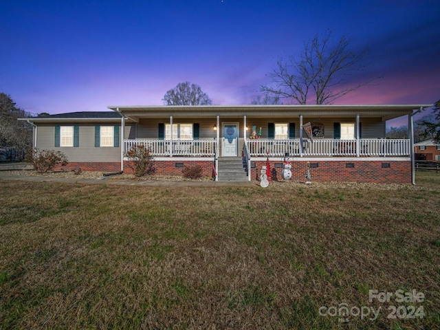 ranch-style house featuring a yard and covered porch