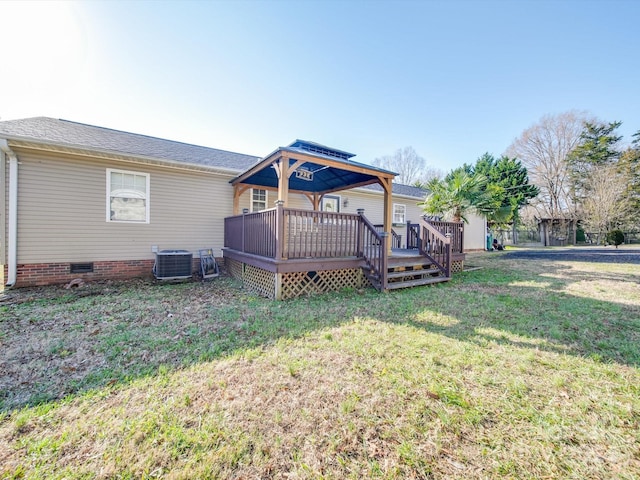 rear view of property with a lawn, central air condition unit, and a wooden deck