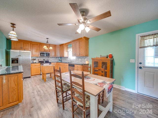 dining area with a textured ceiling, ceiling fan, sink, and light hardwood / wood-style flooring