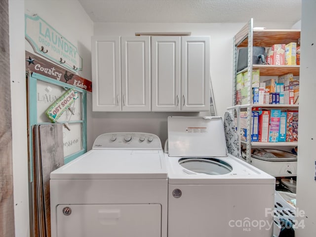 laundry room featuring cabinets, washer and dryer, and a textured ceiling