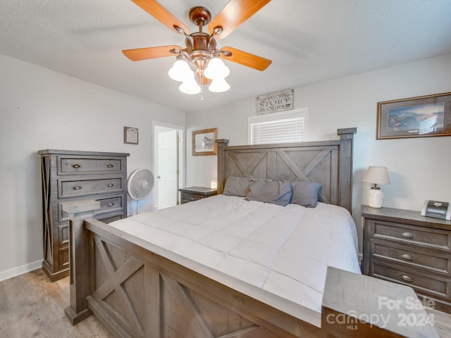 bedroom featuring a textured ceiling, light hardwood / wood-style flooring, and ceiling fan