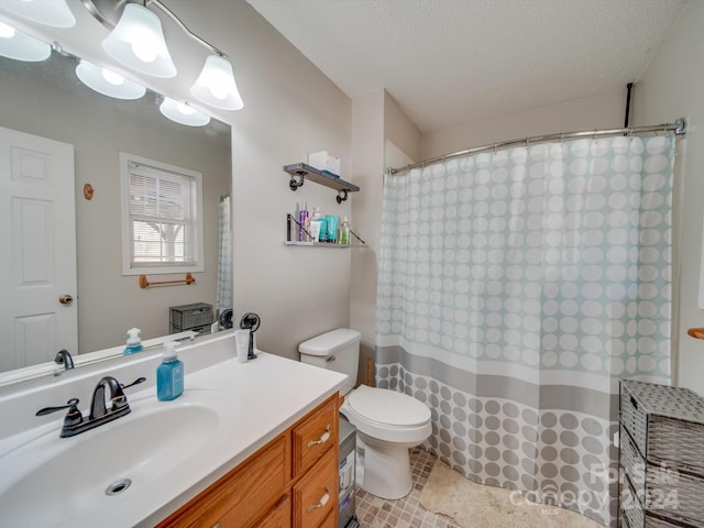 bathroom with vanity, toilet, and a textured ceiling