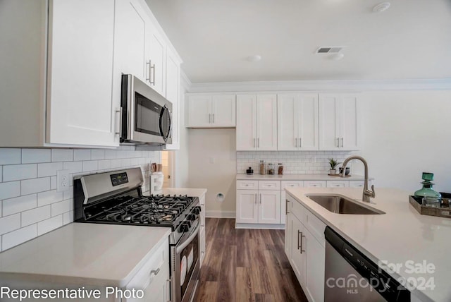 kitchen featuring sink, dark hardwood / wood-style floors, backsplash, white cabinets, and appliances with stainless steel finishes