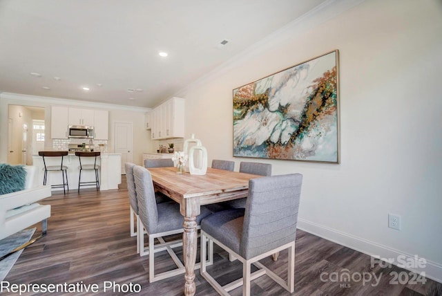 dining room featuring dark hardwood / wood-style floors and crown molding