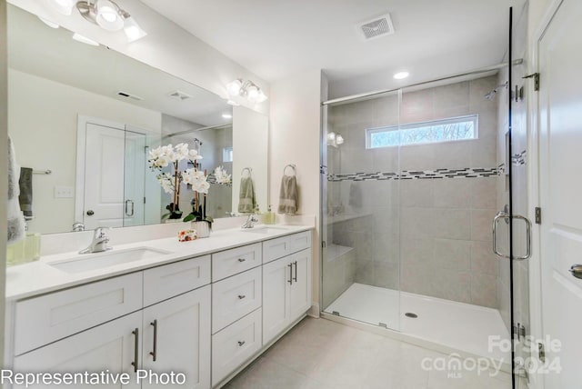 bathroom featuring tile patterned flooring, vanity, and walk in shower