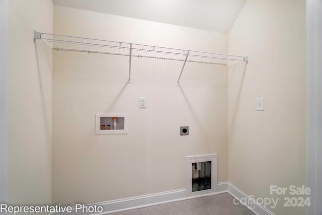 washroom with electric dryer hookup, light tile patterned floors, and washer hookup