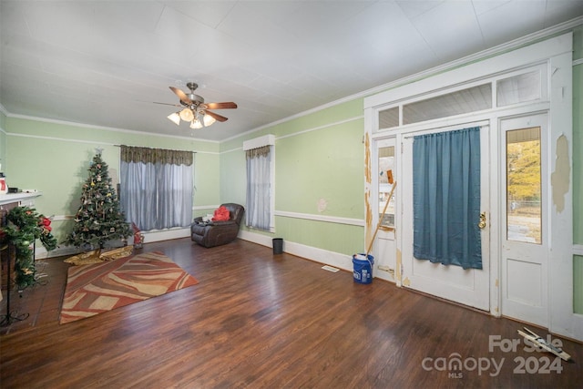 interior space featuring dark hardwood / wood-style flooring, ceiling fan, and crown molding