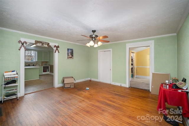 interior space with hardwood / wood-style flooring, ceiling fan, ornamental molding, and a textured ceiling