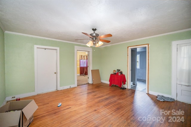 misc room featuring a textured ceiling, hardwood / wood-style flooring, and ornamental molding