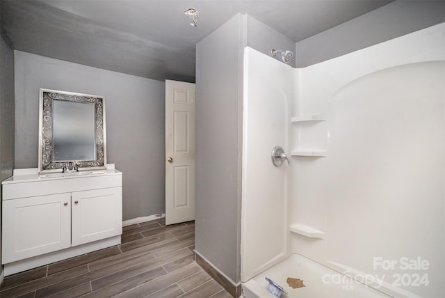 bathroom with a shower, wood-type flooring, and vanity