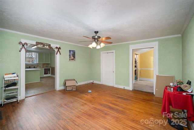 interior space with hardwood / wood-style flooring, ornamental molding, and ceiling fan