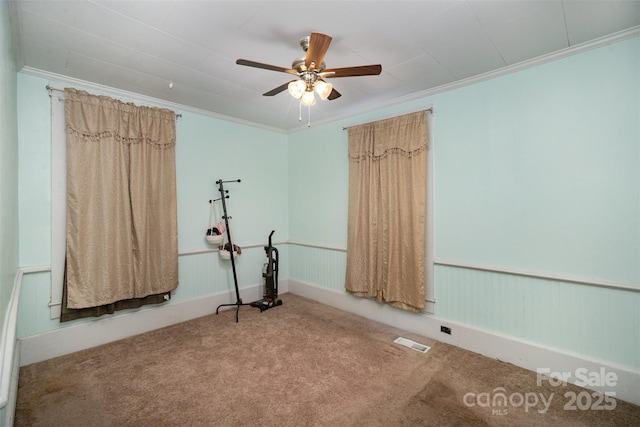 interior space featuring crown molding, ceiling fan, and carpet flooring