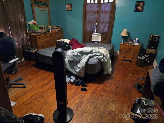 bedroom with cooling unit and wood-type flooring