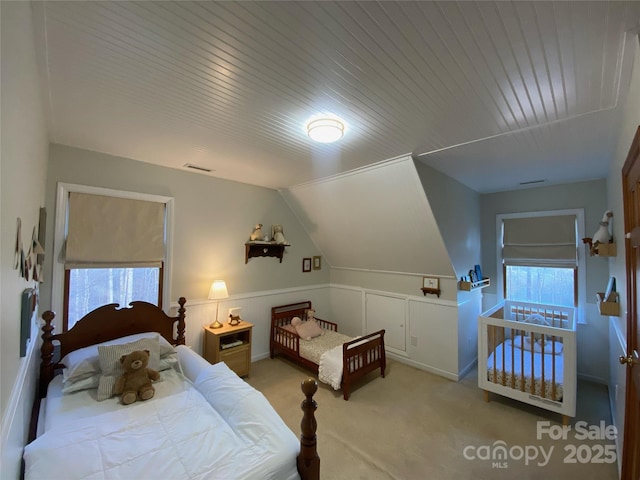 carpeted bedroom with multiple windows, wood ceiling, and vaulted ceiling