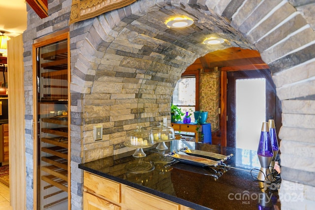 bar with light brown cabinets and wine cooler