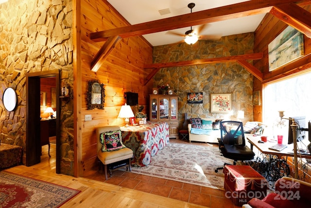 interior space featuring vaulted ceiling with beams, wood walls, and light wood-type flooring