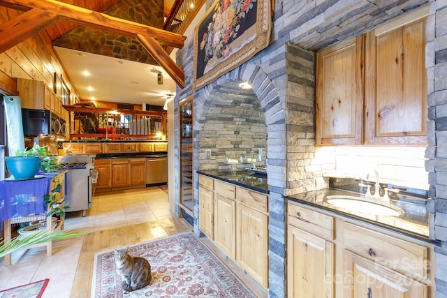 kitchen featuring light brown cabinetry, vaulted ceiling, sink, light tile patterned floors, and dishwasher