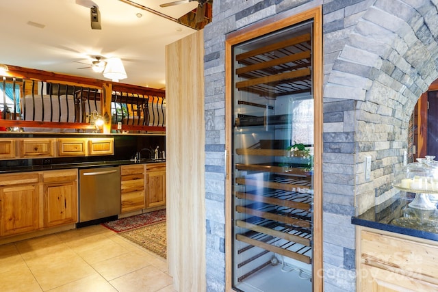 bar featuring ceiling fan, light tile patterned floors, and stainless steel dishwasher