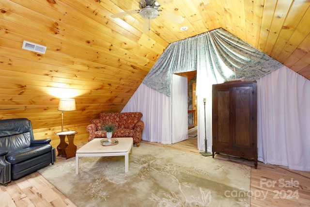 living area featuring wood walls, light wood-type flooring, lofted ceiling, and wooden ceiling