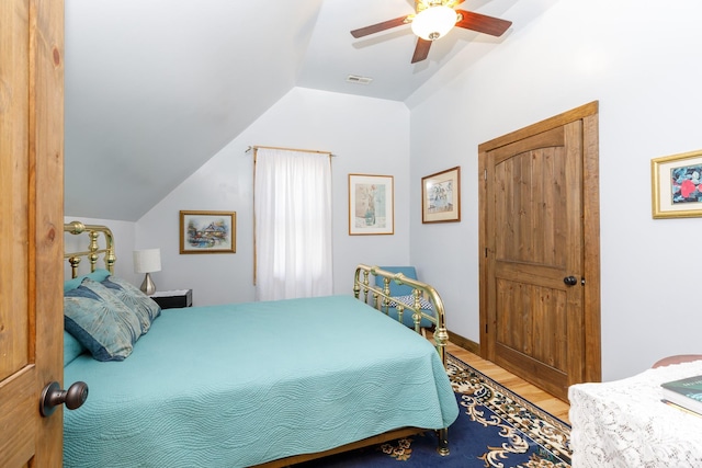 bedroom featuring wood-type flooring, vaulted ceiling, and ceiling fan