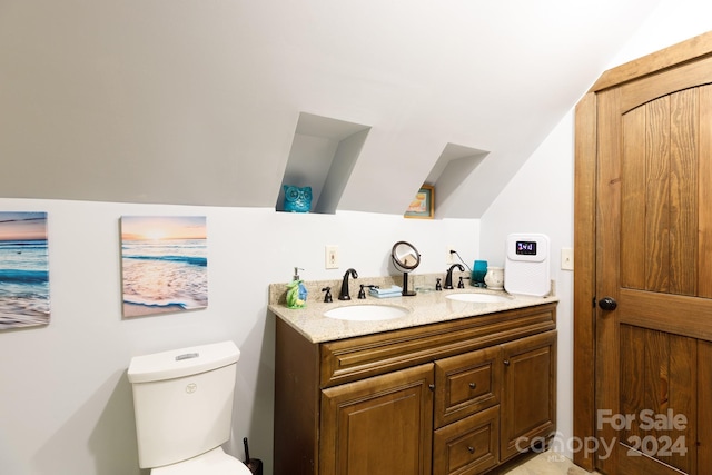 bathroom with vanity, vaulted ceiling, and toilet