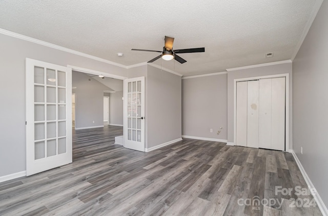 interior space featuring hardwood / wood-style floors, french doors, crown molding, ceiling fan, and a closet