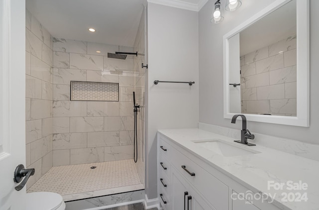 bathroom featuring crown molding, toilet, vanity, and tiled shower