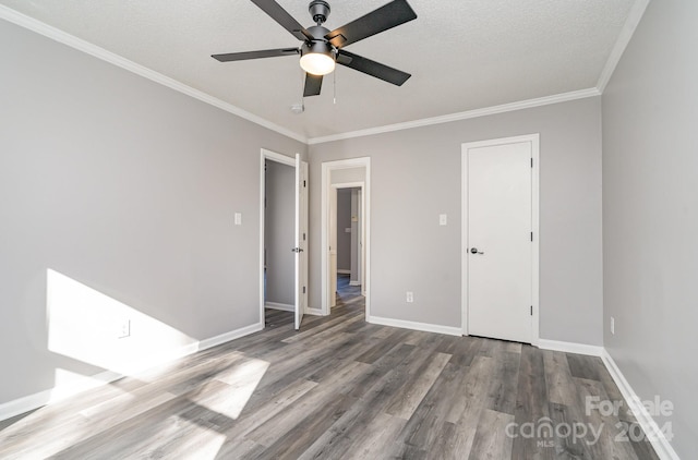 spare room with a textured ceiling, ceiling fan, light wood-type flooring, and ornamental molding