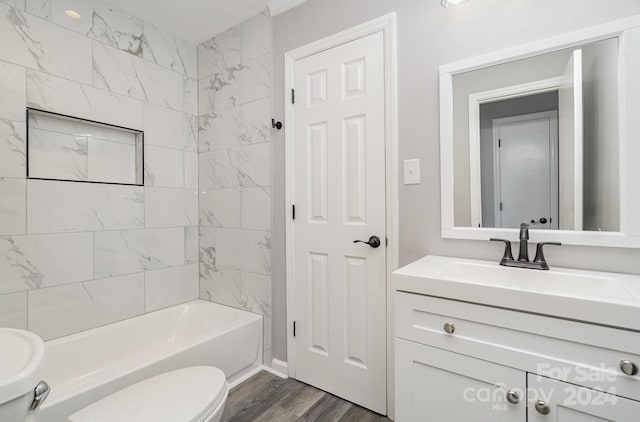 full bathroom featuring toilet, hardwood / wood-style floors, vanity, and tiled shower / bath