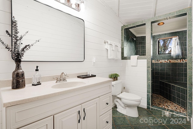 bathroom featuring wooden walls, toilet, vanity, and tiled shower