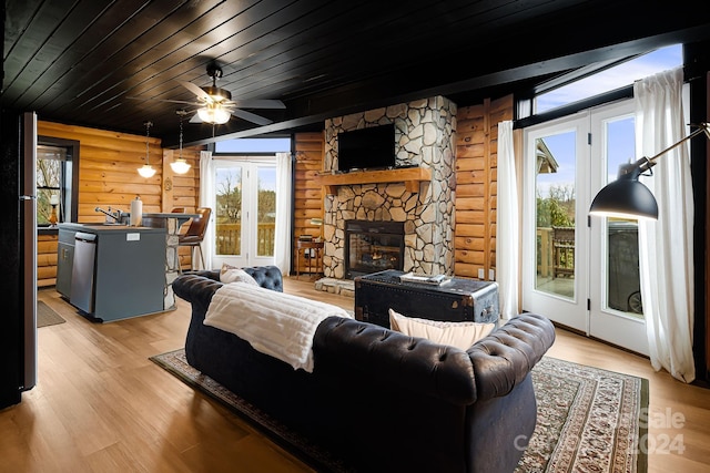 living room featuring sink, ceiling fan, a fireplace, light hardwood / wood-style floors, and wood ceiling