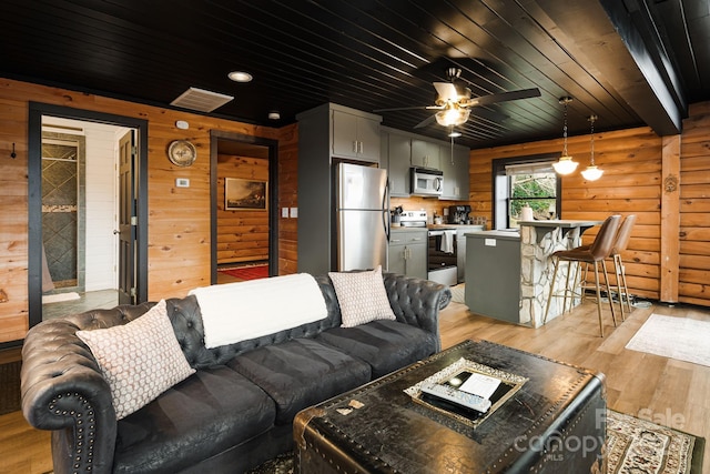 living room featuring ceiling fan, light wood-type flooring, and wooden ceiling