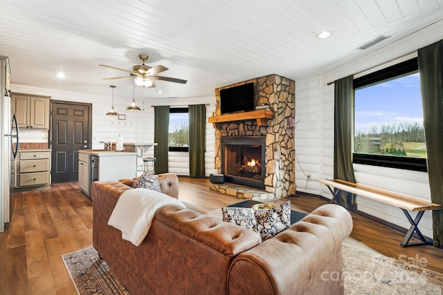 living room with a fireplace, dark hardwood / wood-style floors, a wealth of natural light, and ceiling fan