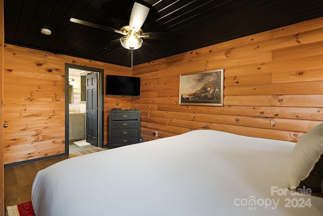 bedroom with ensuite bath, ceiling fan, wooden walls, wood-type flooring, and wooden ceiling