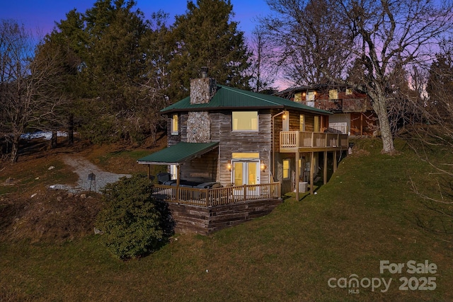 view of front of house with a wooden deck and a yard