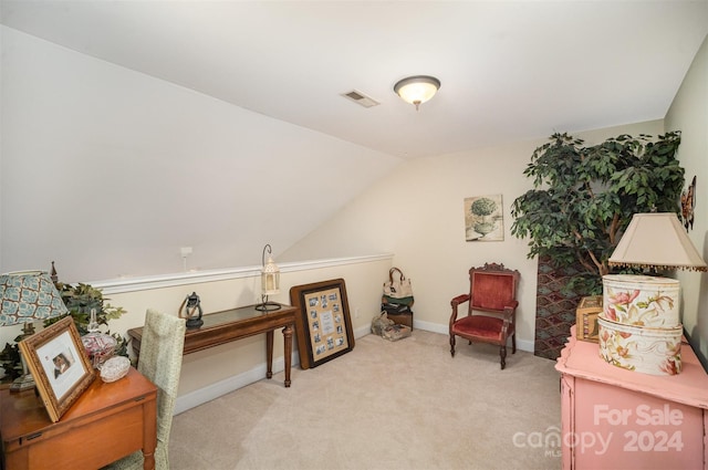 sitting room featuring light carpet and vaulted ceiling