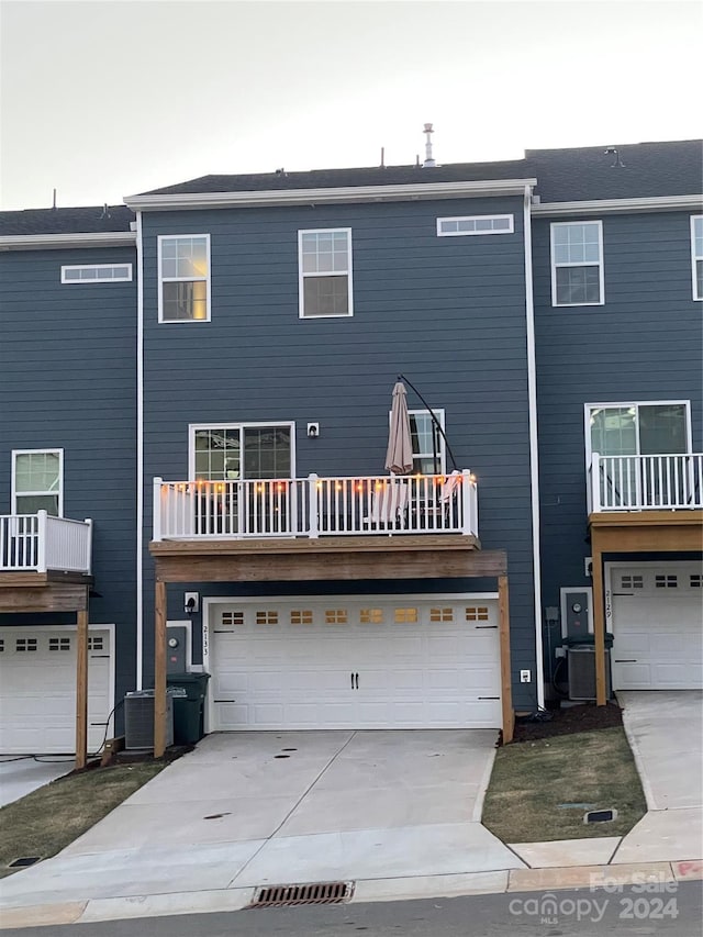 back of property with a garage and cooling unit