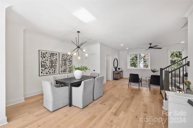 dining room with ceiling fan with notable chandelier, light hardwood / wood-style floors, and ornamental molding