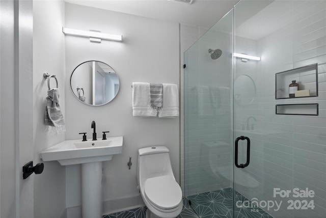 bathroom featuring tile patterned floors, toilet, walk in shower, and sink